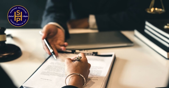 a woman signing a document with a man sitting across from her